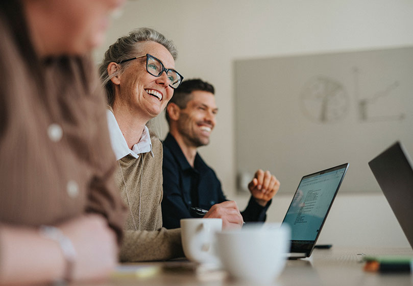 Woman and man smiling in a meeting