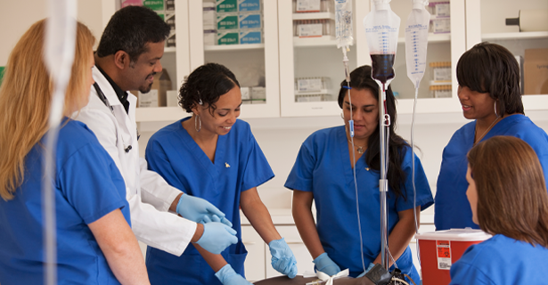 Undergraduate students in scrubs observing