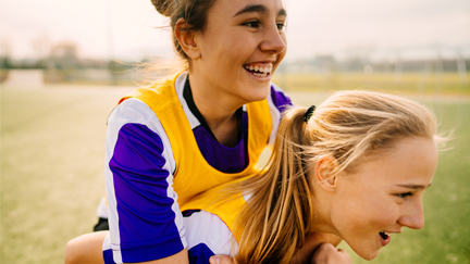 Two female soccer players smiling