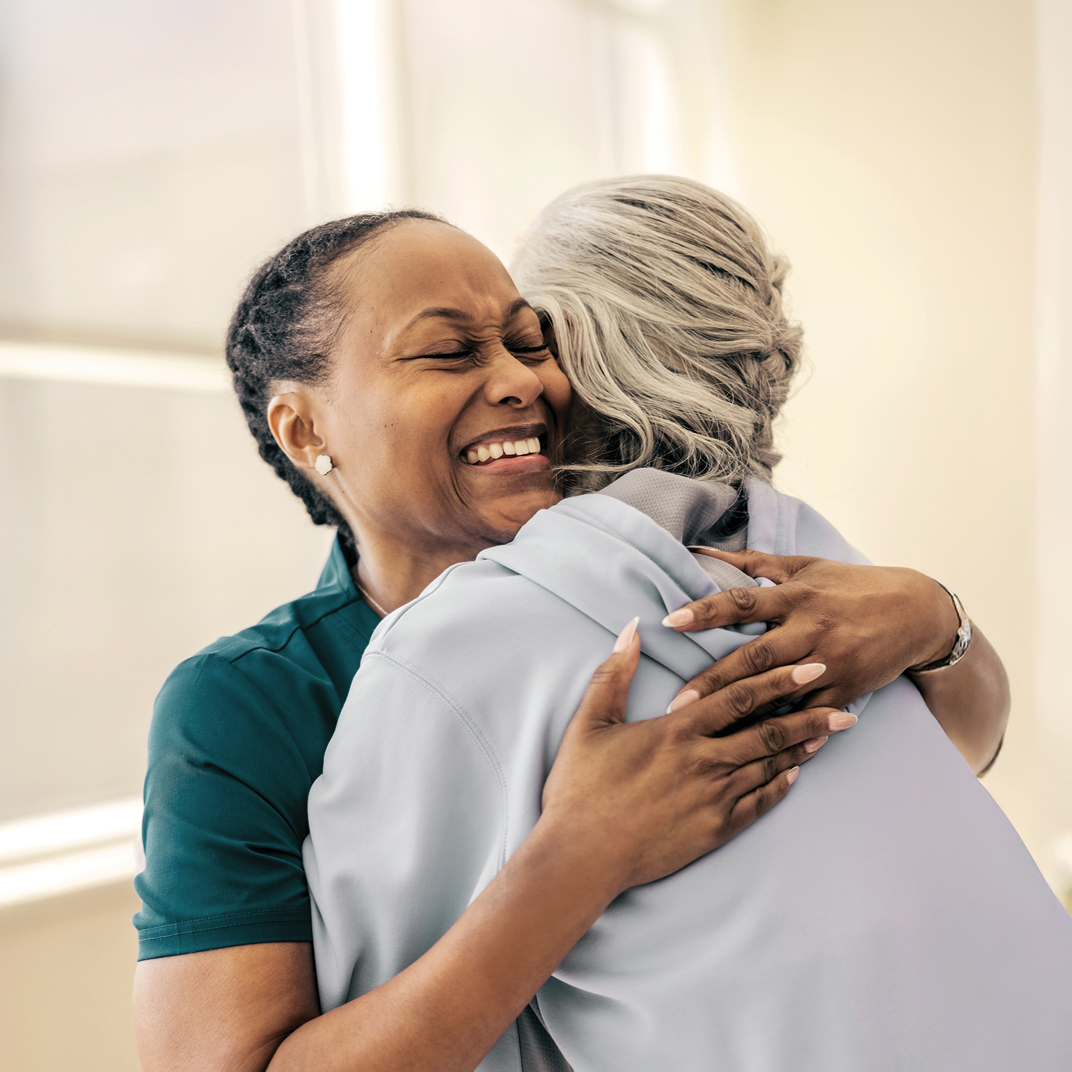 Woman nurse hugging woman patient